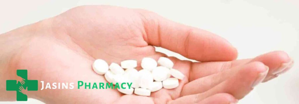 person holding white tablets in their hand
