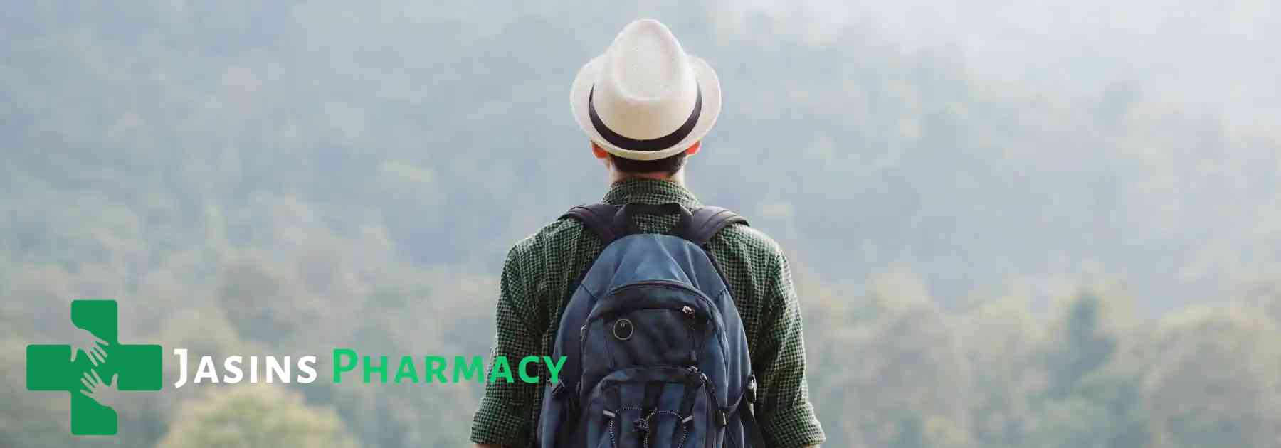 traveller wearing sun hat and backpack admiring view of forests