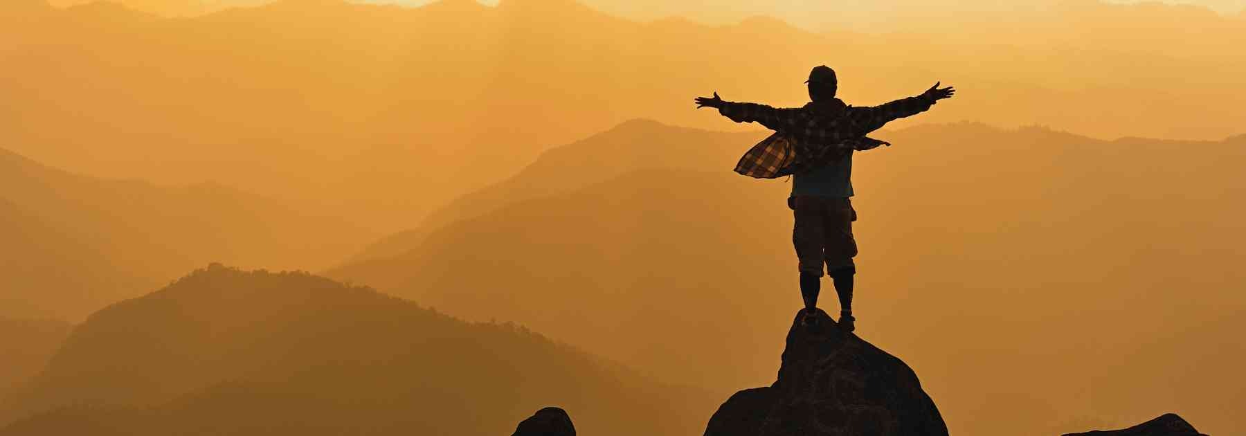 silhouette of traveller admiring view of mountains