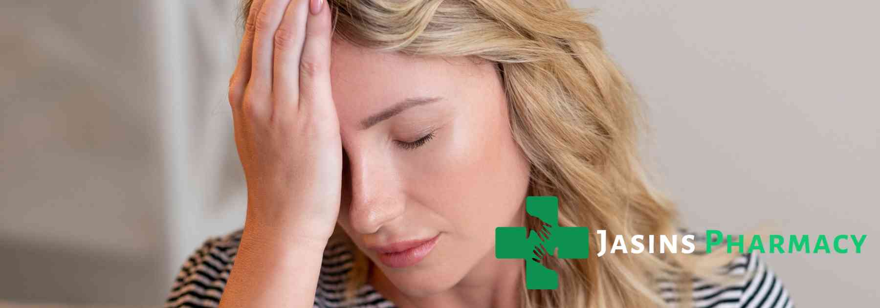 woman pressing her hand to her forehead in discomfort
