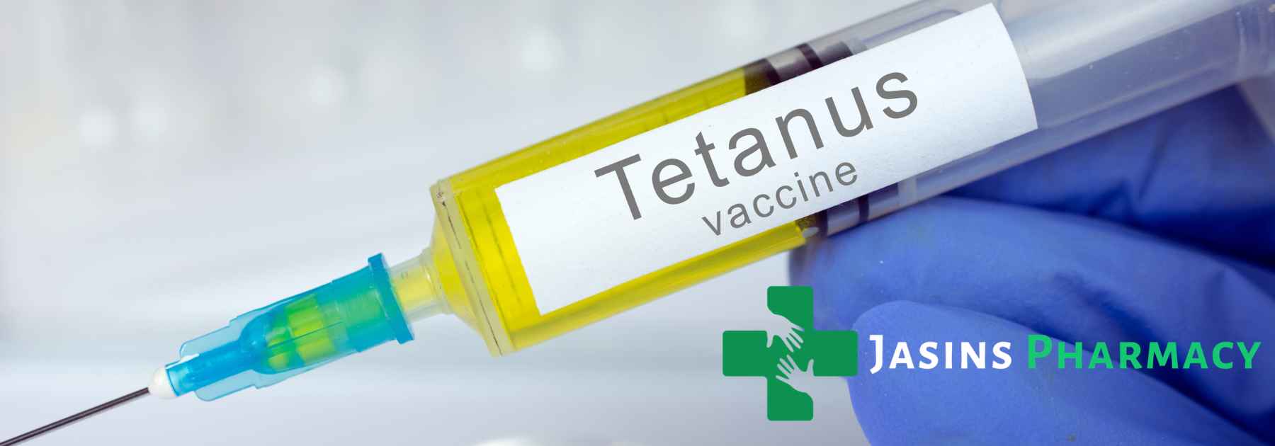 person wearing blue medical glove holding tetanus vaccine