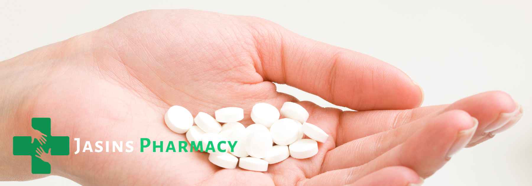 person holding white pills in the palm of their hand