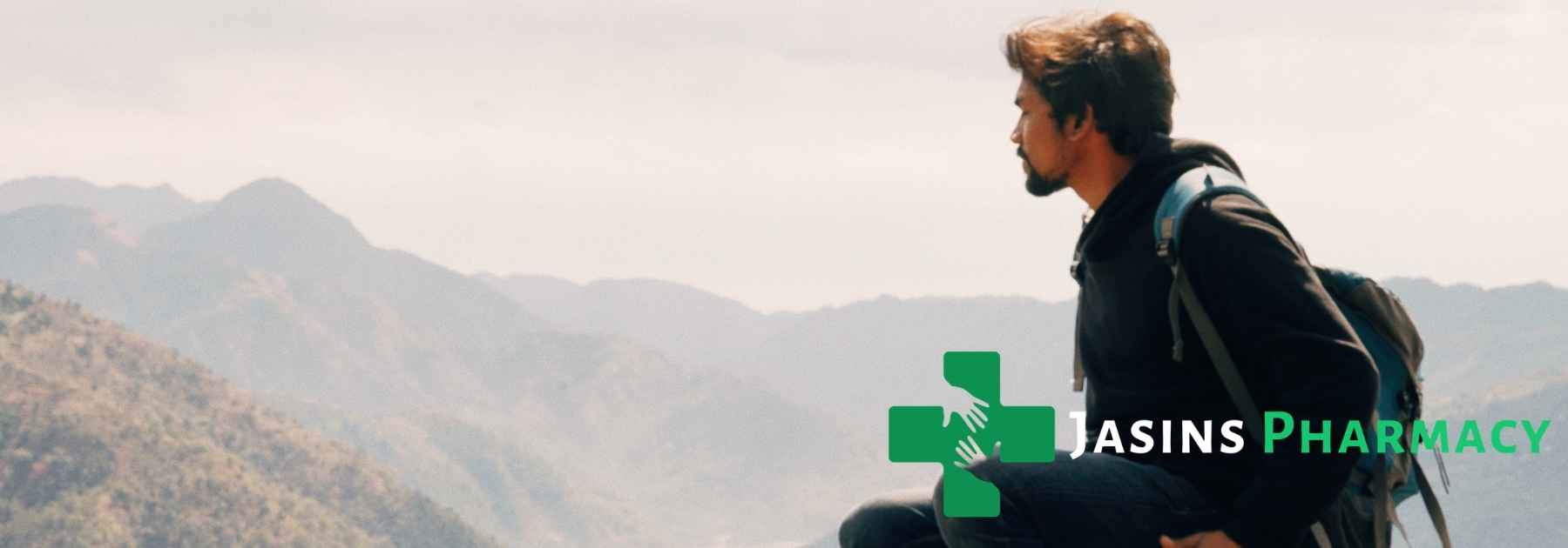 young man in backpack looking at view of mountains